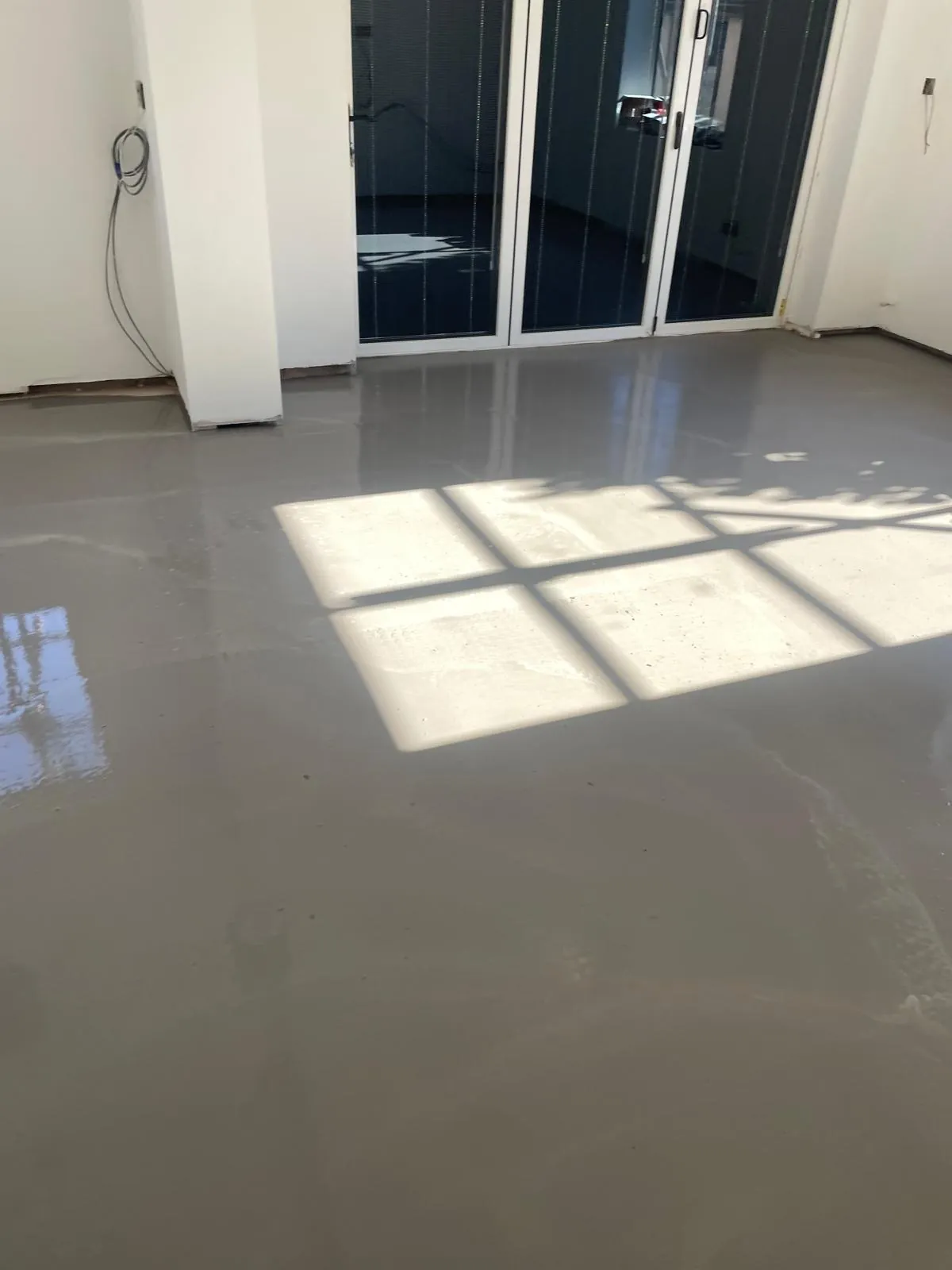 The screed curing by the garden doors